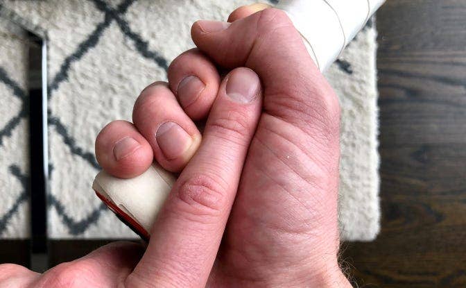 hand gripping a racket with a finger's worth of space between fingertips and palm