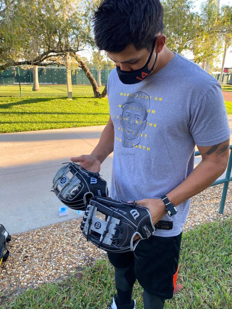 Rio Ruiz holding two wilson ball gloves