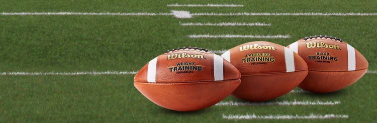 Closeup of three training footballs on a football field