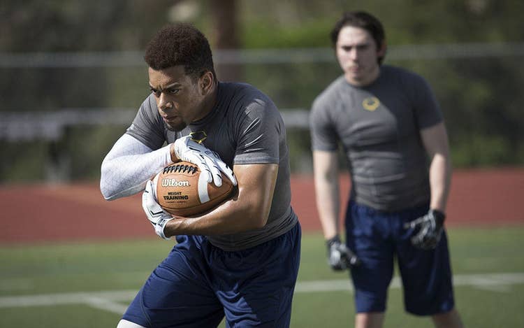 football players at practice using training footballs