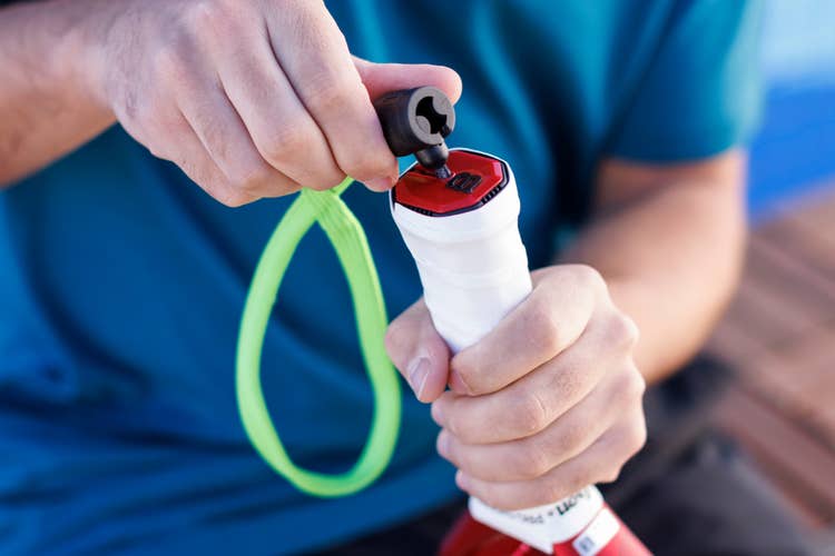 Detaching Wilson's green padel zipcord