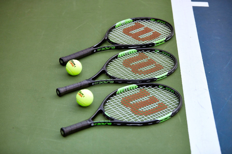 Three rackets lined up on the court