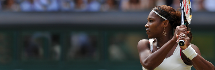 Side shot of Serena Williams holding her racket high
