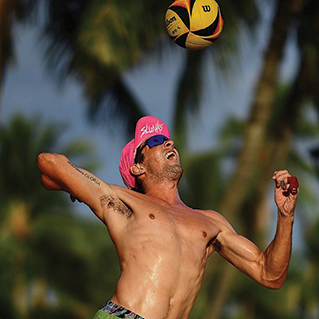 Troy Field jumping to hit a Wilson AVP volleyball