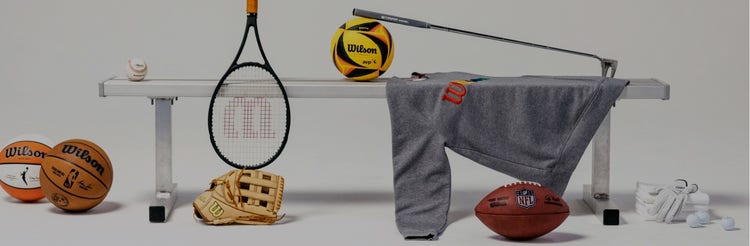 Wilson balls, racket, club, and apparel sitting on a bench