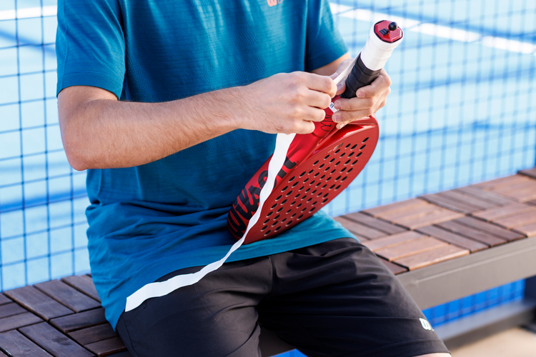 Padel player wrapping the grip