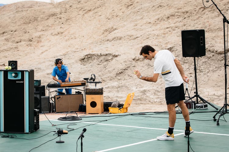 Roger Federer serving on a studio court