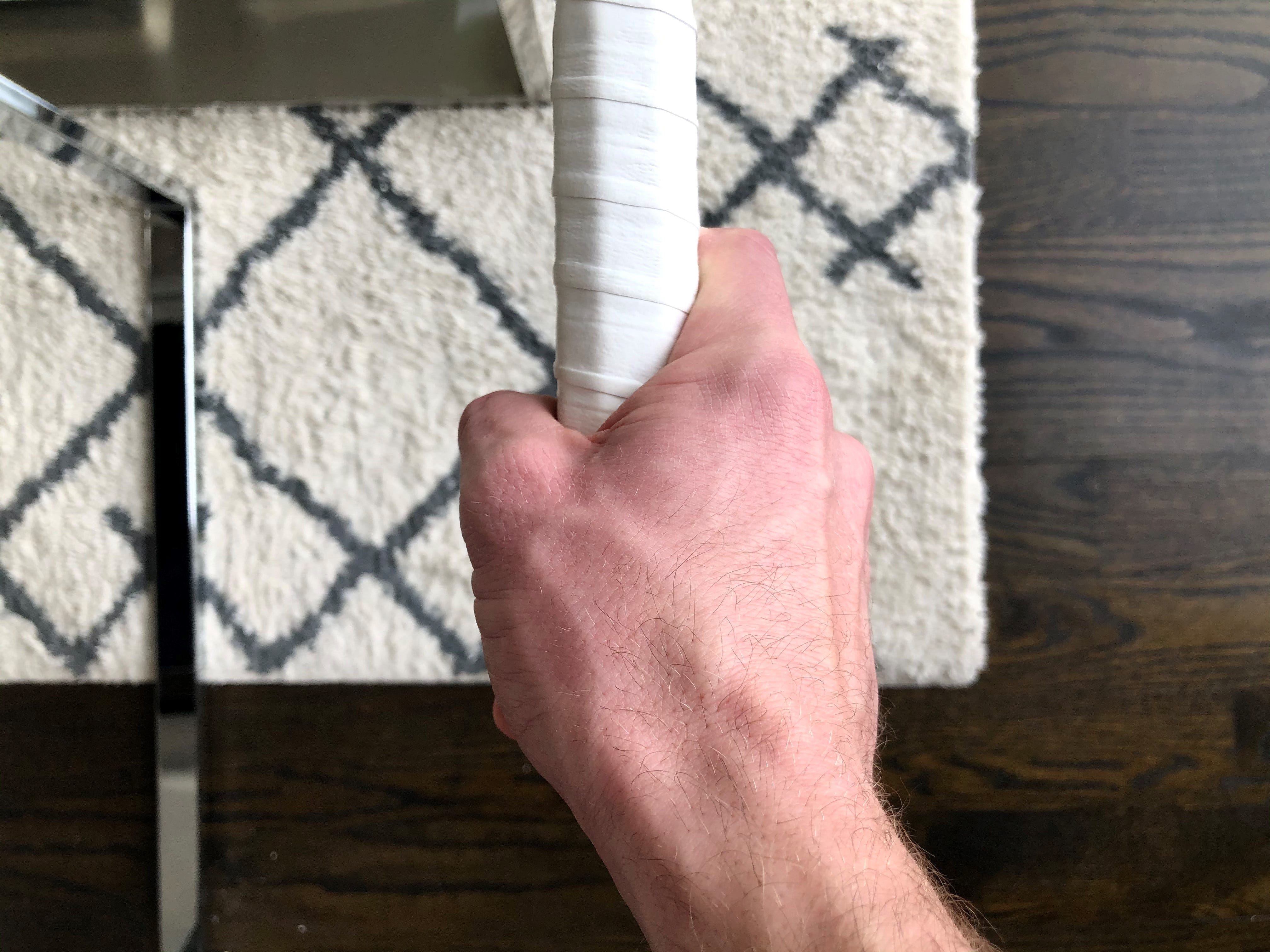 a hand gripping a racket with the continental grip 